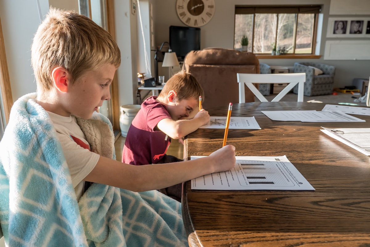 Two boys working on homeschool work at kitchen table